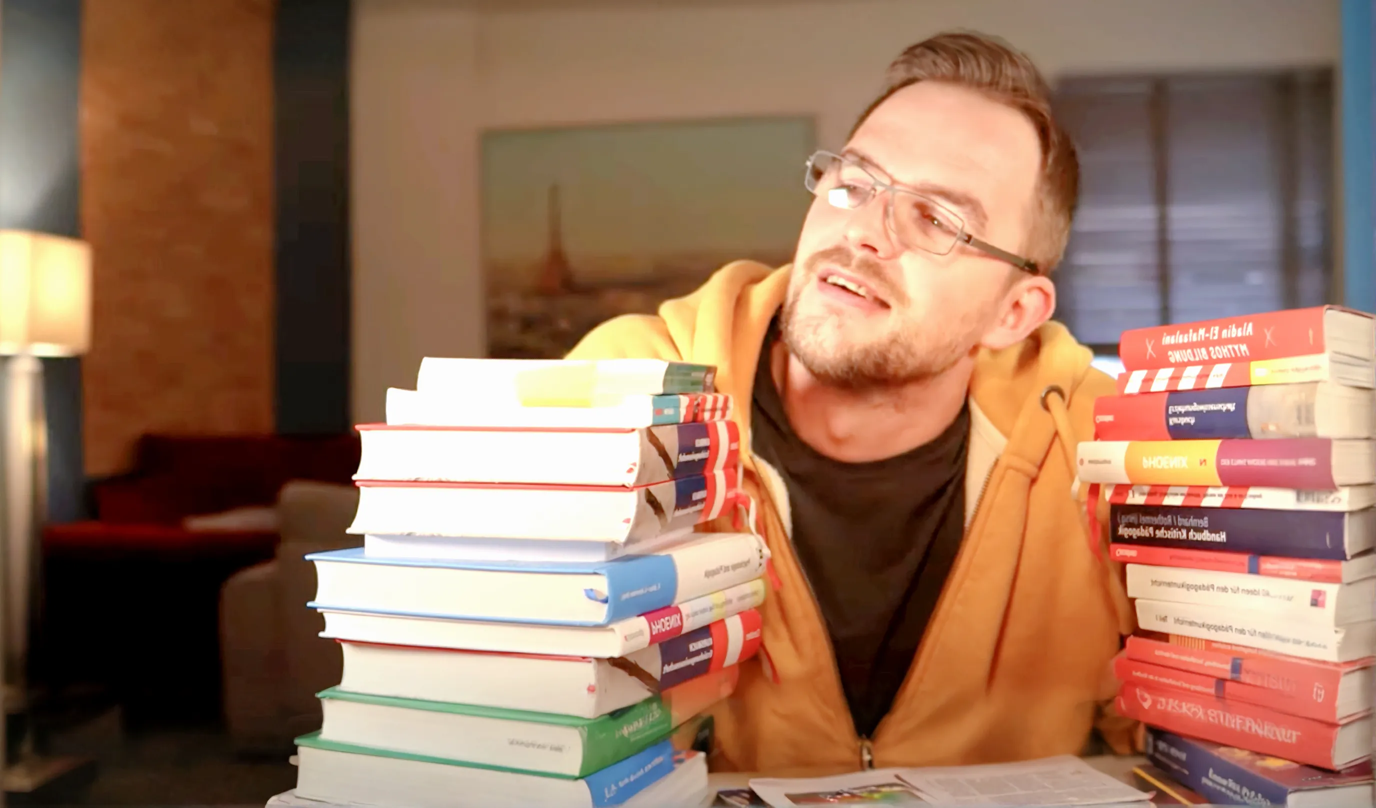 Tobi zwischen zwei hohen Bücherstapeln